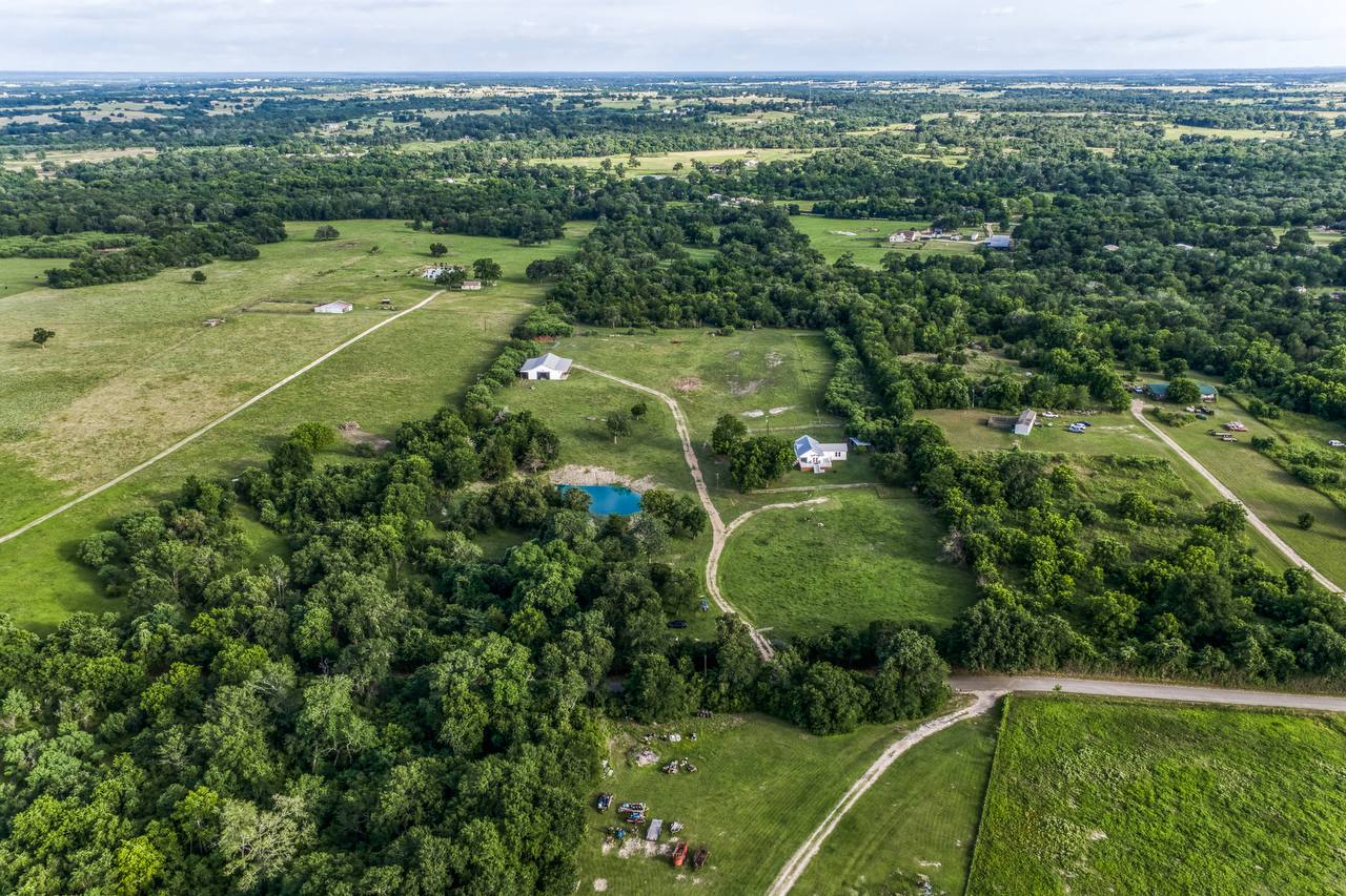 Aerial overview — house, barn, and stocked pond