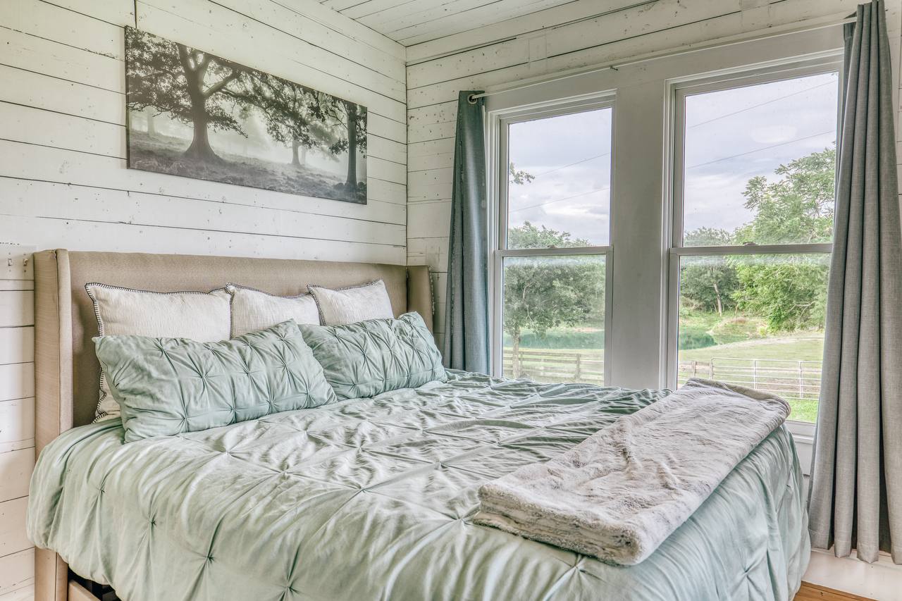 Bedroom with shiplap walls and pond views