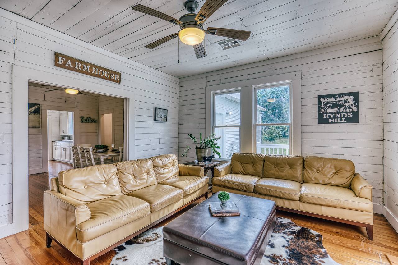 Living room — leather sofas and FARMHOUSE sign